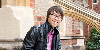 smiling male student sitting on steps
