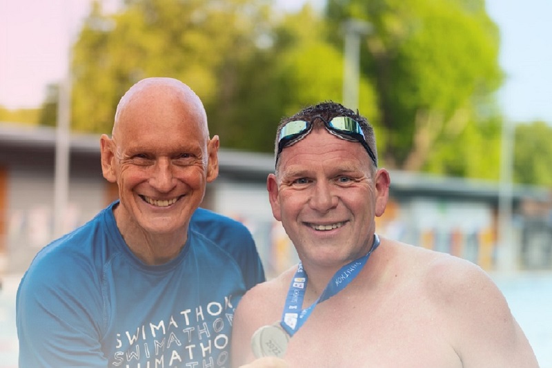 swimmer and coach smiling at a swimathon