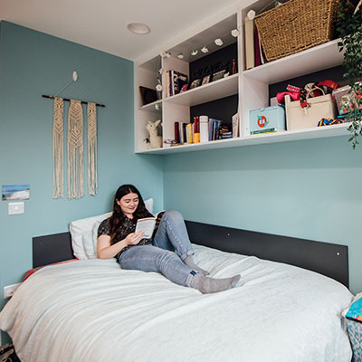 Student reading on her bed Elms BT2