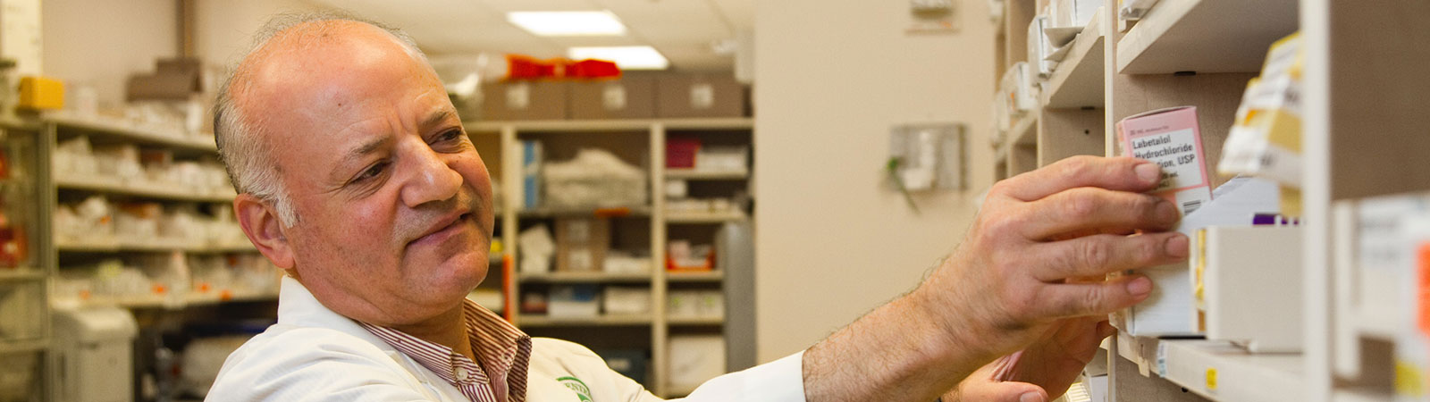 Healthcare professional taking a box of tablets from a shelf