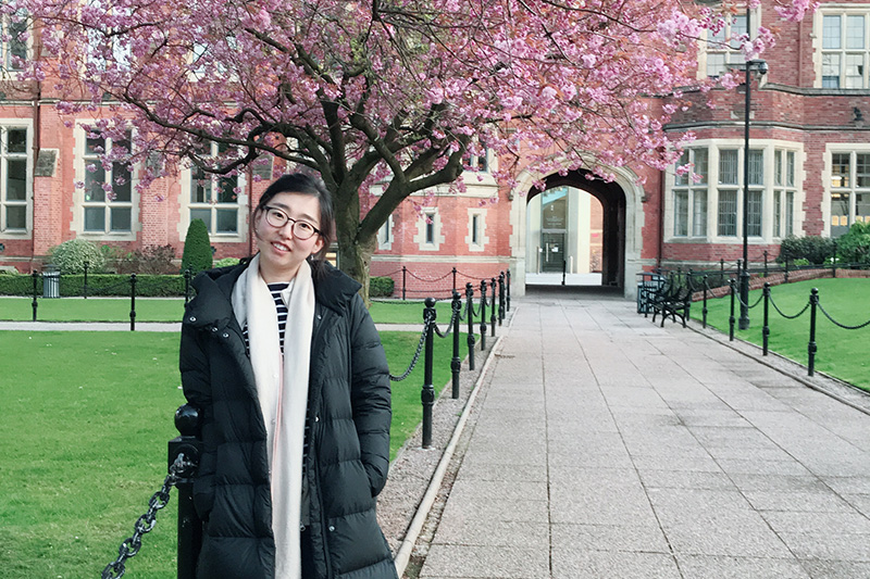 Yuan at our beautiful campus  in front of a cherry blossom tree