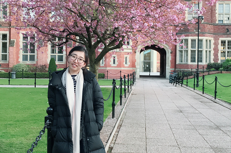 Yuan at our beautiful campus in front of a cherry blossom tree