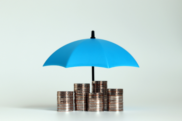 Image shows stacks of coins being covered by a blue umbrella