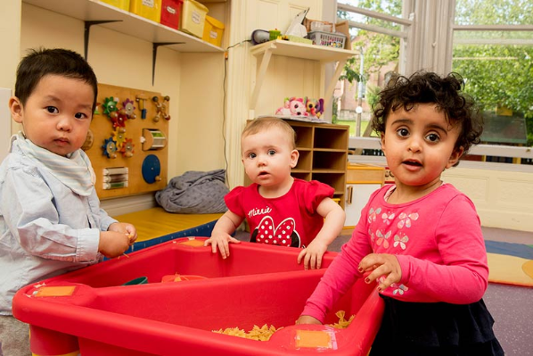 Image shows three children playing together in Queen's Childcare