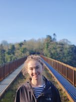 Image of Volunteer SU Intern, Phoebe, standing on a bridge