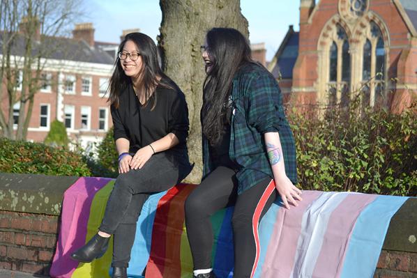 Two students with LGBTQ+ and Trans flags