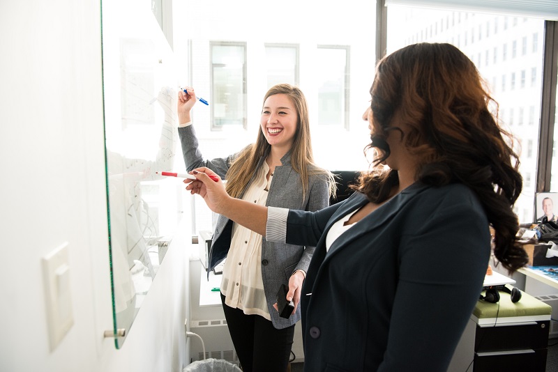 Two women at a white board