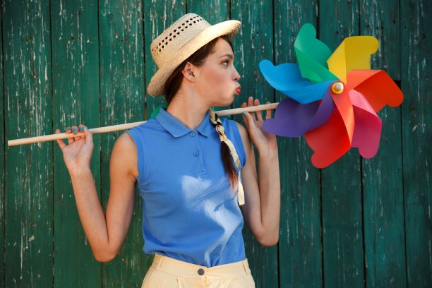 LGBTQ+ D&I girl blowing rainbow coloured windmill
