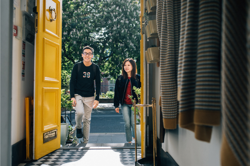 two international students walking through a doorway at Queen's University