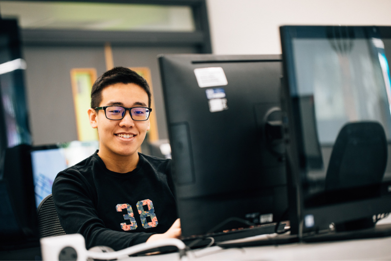 male student sitting at a pc