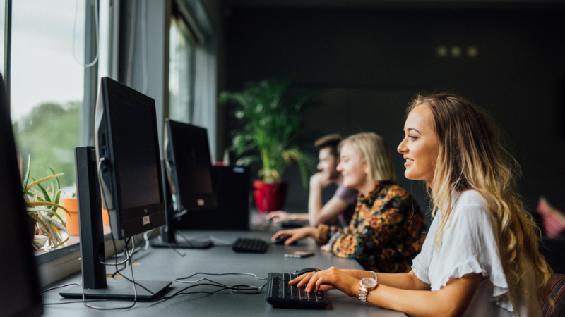 students sitting in a row all on PCs