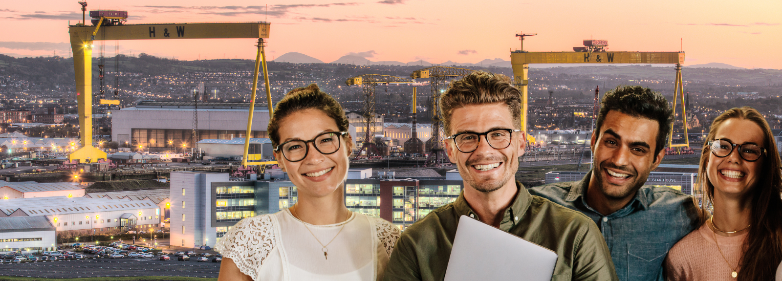 students standing in front of a background of the Harland and Wolff cranes