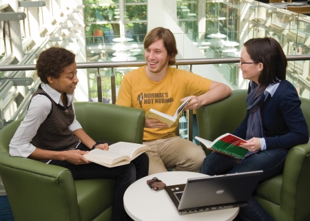 Three students chatting in the McClay Library