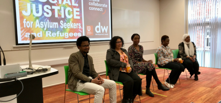 panel members sitting on chairs at an event