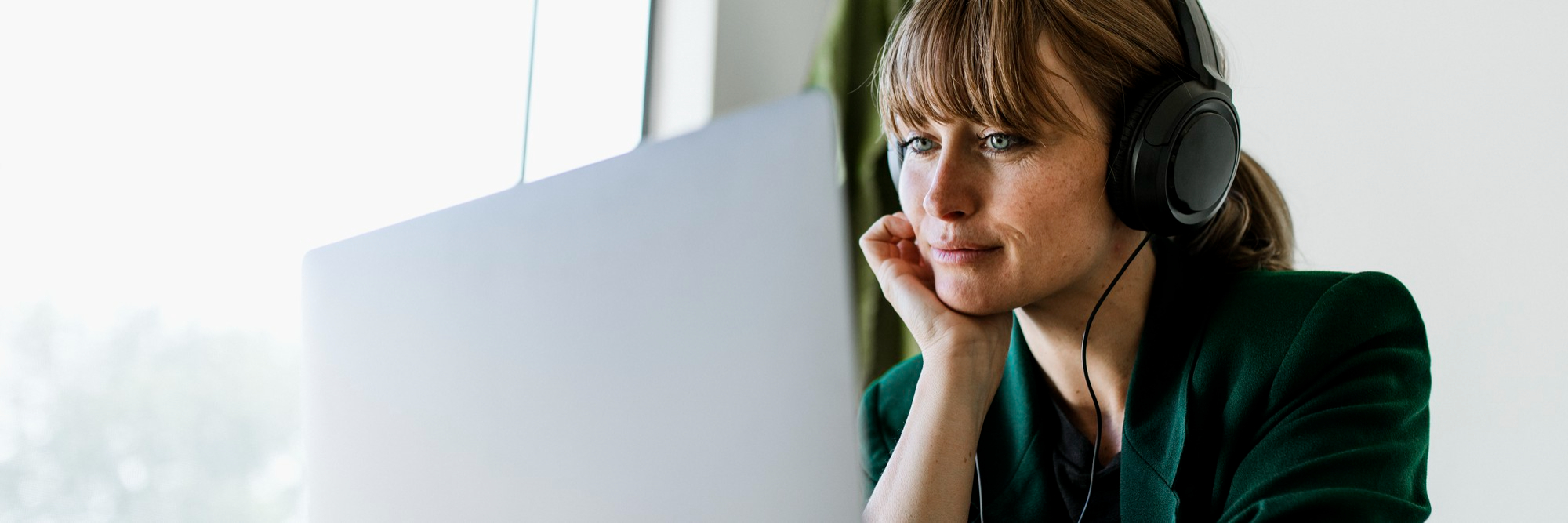 Woman working with laptop, headphones on