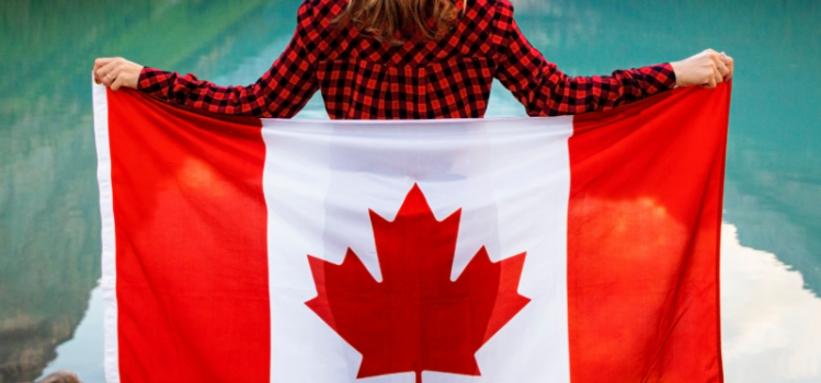 lady standing with her back to camera holding a Canadian flag