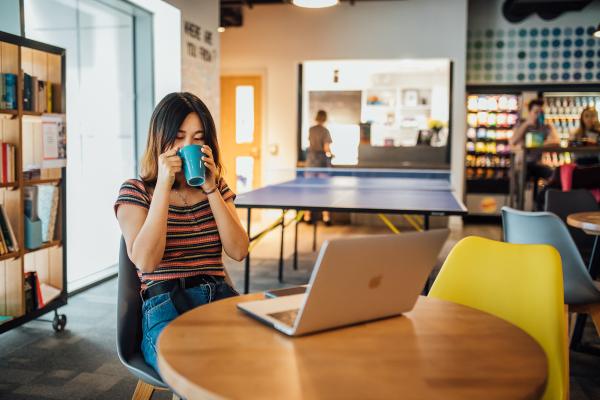 A student drinking coffee in QUB accommodation.