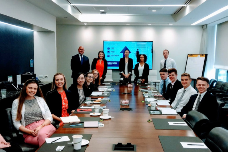 students sitting down in a board room in New York whilst visiting a company