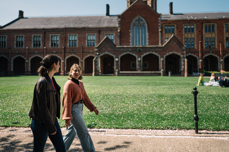 Two students walking through the quadrangle at Queen's.