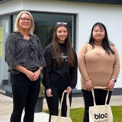 two students standing with an employer inside employer premises on work shadowing week