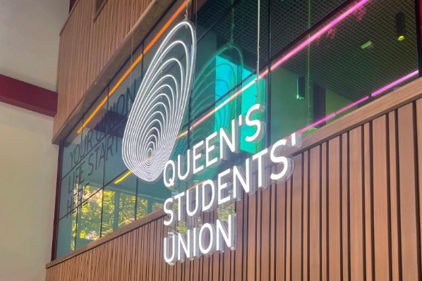 Image shows the neon 'Queen's Students' Union' sign at the front of One Elmwood