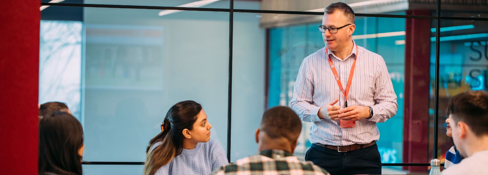 employer talking to students sitting at a table in a group