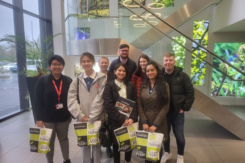a group of students standing together holding goodie bags at work shadowing week