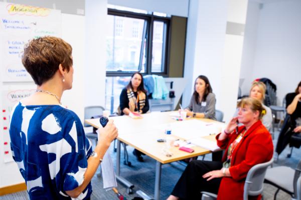 Image shows a leader delivering training to staff members