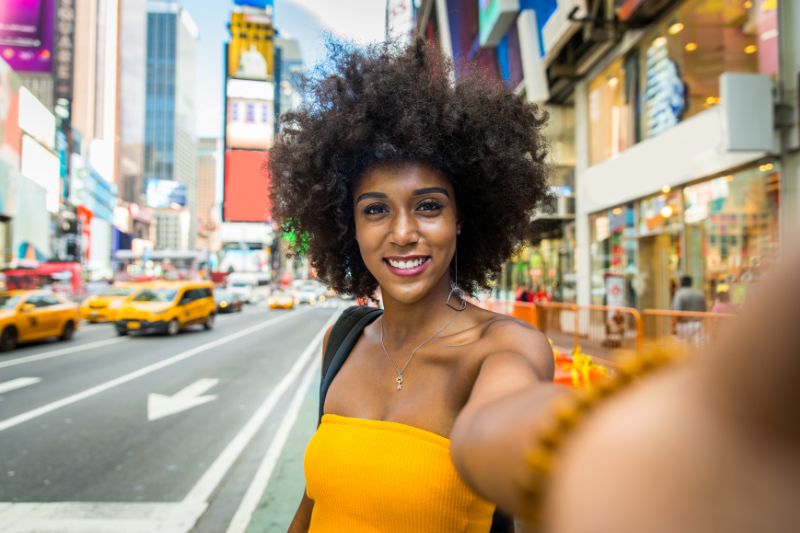 student taking a selfie in a busy city street