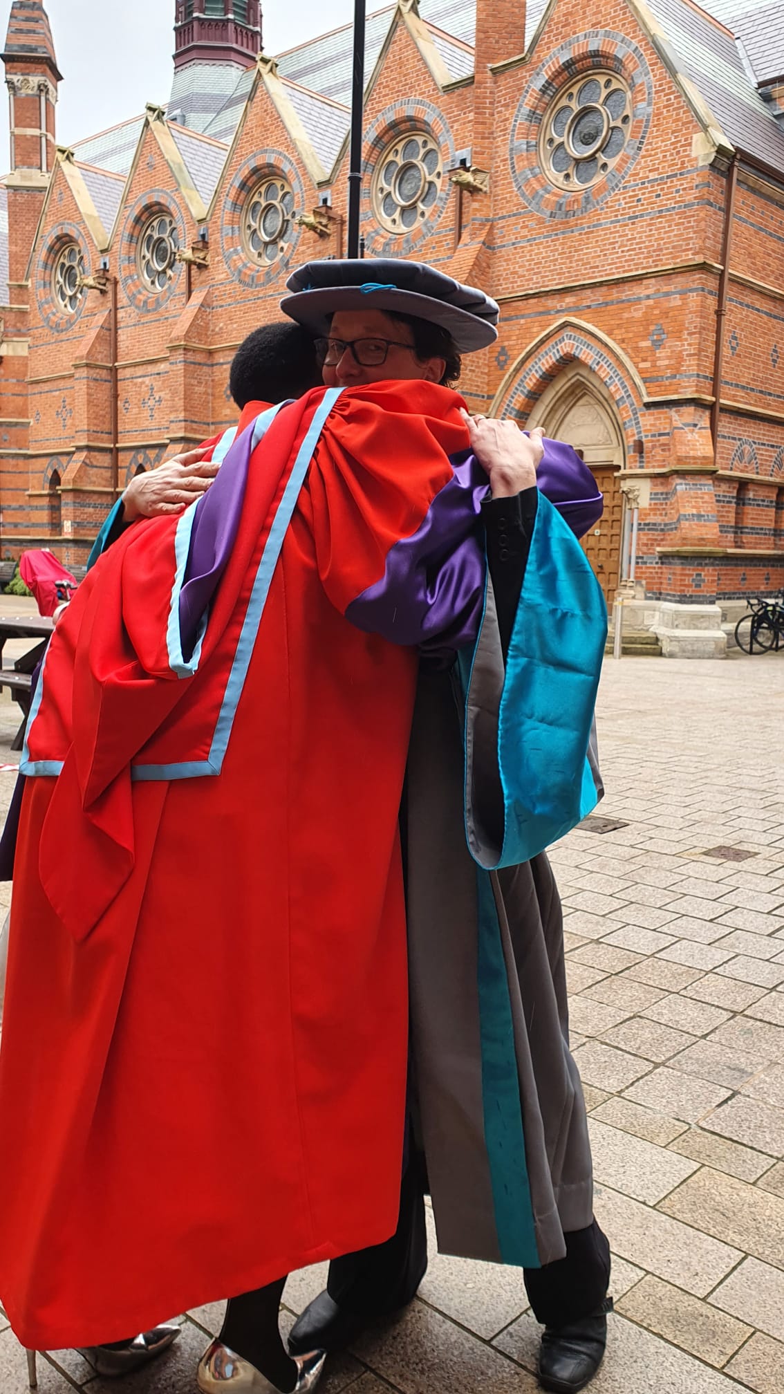 An informal campus pic of Dr Belluigi and Dr Queiroz embracing on the latter’s graduation day that had been delayed due to Covid restrictions.