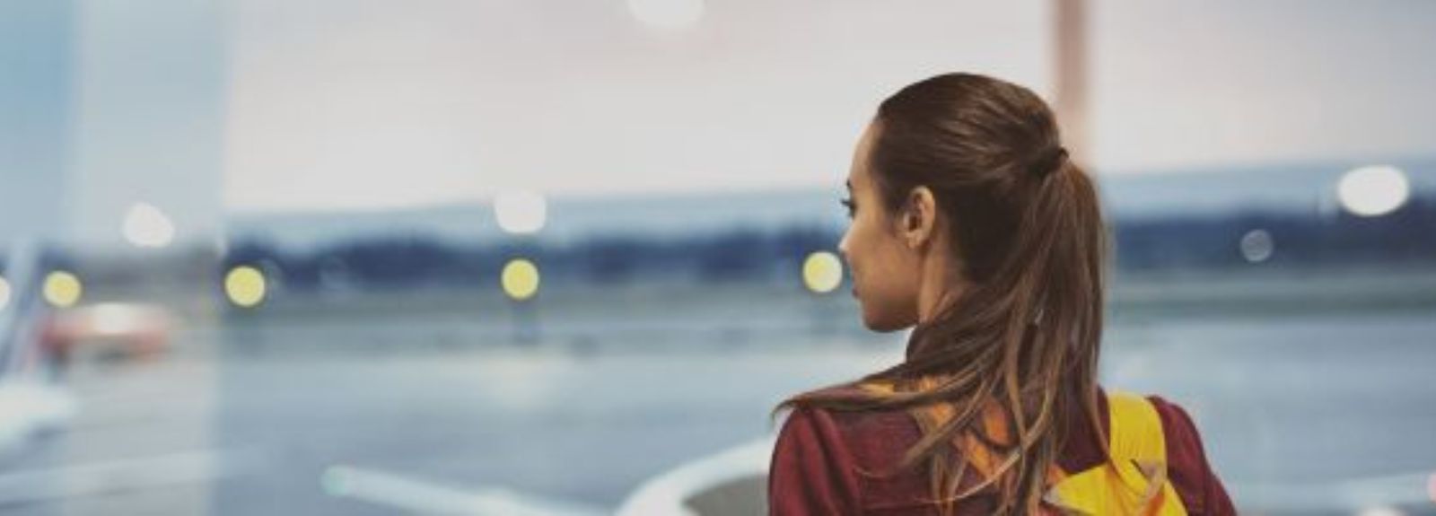 student standing on a runway with a backpack on