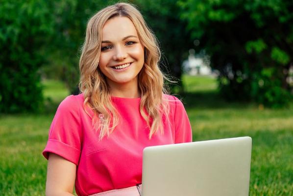 female student sitting on laptop smiling