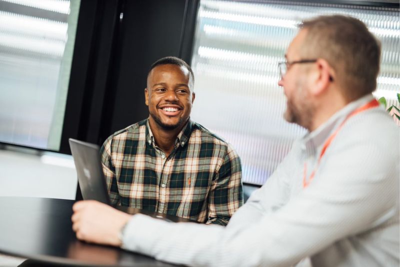 student sitting talking to a staff member