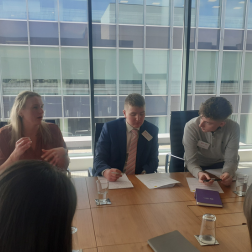 students sitting at a table with employer