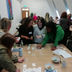 students stnading together round a table playing a game at an employers' premises