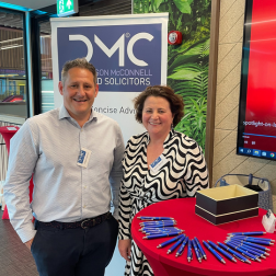 two employers standing at an events stand table