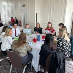 students sitting at a table with employer