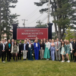 students standing at a sign for the University of Massachusetts