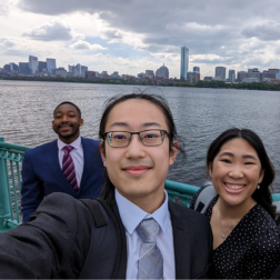 students standing together taking a selfie with sea in background