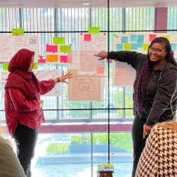 students standing with a flip chart presenting to other students