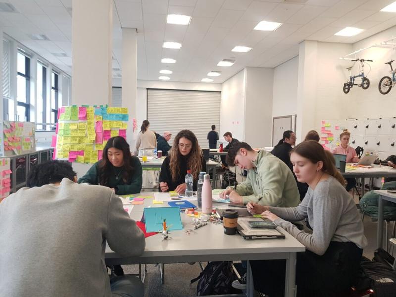 students sitting at a table being creative in a workshop