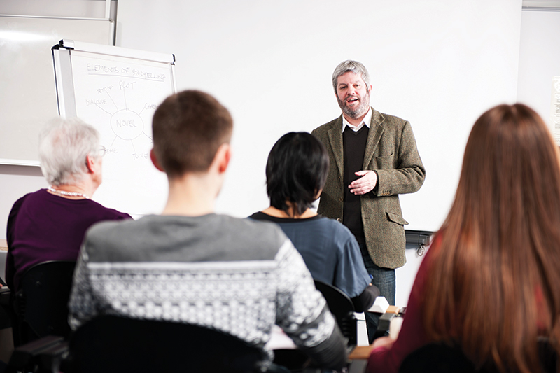 Image shows a man teaching a class