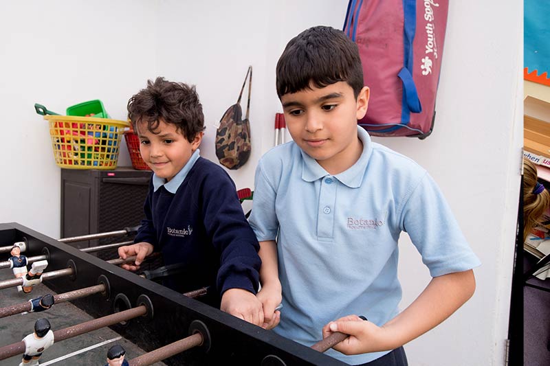 two boys playing table-top football together