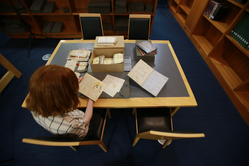 Staff member looking at Eva Price letters in Special Collections Reading Room.