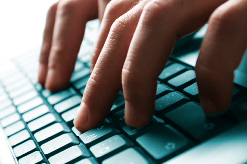 Close up image of fingers typing on a computer keyboard