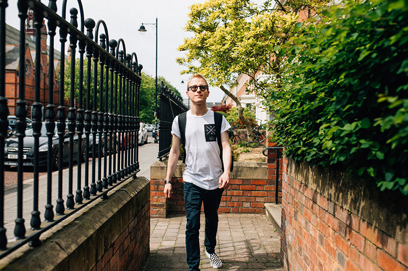 Male student walking past University Street Houses