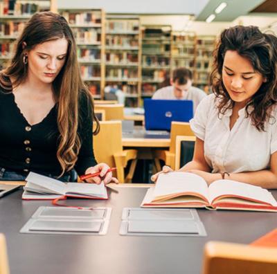 2 female students studying in the McClay Library