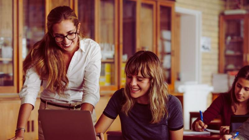 two female students studying and chatting at a table