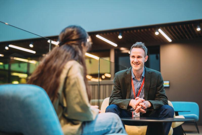Member of staff (male) talking to a female student
