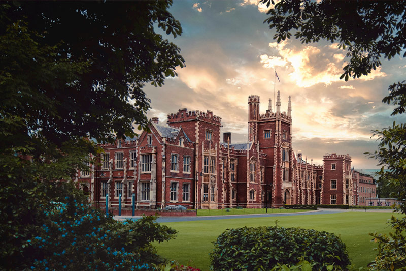 The sun breaks from behind the clouds over the Lanyon Building at Queen's University Belfast (Jul., 2022). Credit: K Hodge
